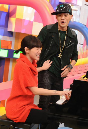 周杰伦（右）教小Ｓ如何用苹果弹钢琴，小Ｓ假装投入弹琴，边突袭摸他的腹肌。图片来源：台湾《中国时报》