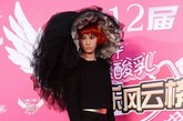 中国版“Lady Gaga”尚雯婕再一次以黑色蚌壳状黑纱帽抢镜成功，搭配红发绿眉毛变身“红毛黑寡妇”。