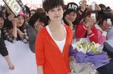 李宇春英气十足的红色开衫外套，白色哈伦裤是今季的流行。