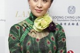 孔雀绿的长款旗袍上有如孔雀羽毛的图案，虽然颜色上有些老气，但是刘嘉玲的气质高贵完全hold住，像是一个老上海的大户人家小姐。
