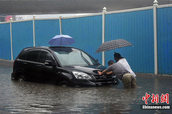 武汉暴雨致多处渍水 市民过路招数多