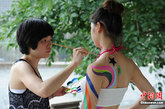 云南省昭通市水富县西部大峡谷景区举行人体彩绘节，身着性感比基尼的美女在景区内各大景点演绎人体彩绘艺术，吸引了众多游客眼球。图为人体彩绘现场。张浪 摄

