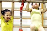 广东佛山李宁体操学校，两名女孩在做基础训练。
