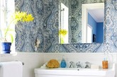 复杂图案的壁纸，将目光聚焦于此，给白色的卫浴间加点色彩，改变单调、冷清的格调。洗手池上的镜子，不仅可以增加空间感，还可以将室外的色彩反射进来，使整个空间更自然，更温暖。
