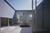 Horibe Naoko Architects Office设计的House in Naruto利用构造方式来抵御这个易受洪水侵袭的地块。这个内向型的住宅围绕一个开放的庭院，为业主夫妇提供了一个私密的休闲空间，同时又给市内创造了良好的自然通风和充足光照。建筑师将洪水灾害考虑到设计中，建筑基础和地面设计的非常坚固，而且呈一定角度，可以帮助泄洪。各个房间围绕中心庭院形成一个回路——这一空间形式同样反映在建筑外观上，形成了一个混凝土的月牙形住宅。（实习编辑李丹）