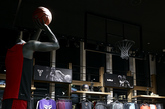 店铺入口处和中央的两个展台分别陈列 Nike Basketball 和 Jordan Brand 当季精品，同时搭配巨型荧幕播放宣传片。地板则特别设计为老式篮球馆的人字形拼花，并描上球场的界线。球衣模特以手抓篮球或是投篮姿势被放立在特别位置，角度对应高处特设的篮筐，相信爱篮球的同学走进店内定会激动得血脉喷张吧。（实习编辑：容少晖）