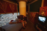 贫民家园：艾德里安与儿子卡洛斯正坐在床上看电视，他们居住在“大卫塔”第24层。（网页截图）