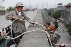 西安：老人悬城墙拔草