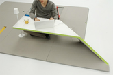 这个地板家具非常简洁，将其铺装地上的时候就是简单的地板，可坐在上面玩耍。但是随意折叠一角就可以变出一个小桌子出来，按照折叠的技巧，还可以折叠出靠椅等之类的家具。这样的设计，节省空间，而又不失美观，非常有创意。（实习编辑：辛莉惠）