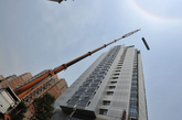 2014年6月24日，北京海淀城管、公安、消防等部门，首次动用260吨重型吊车，对韦伯时代中心C座近百米高楼顶的违建进行拆除，违建面积达1629.6平方米。（实习编辑：辛莉惠）