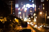 2014年9月24日，中国香港，一男子站在桥上眺望香港湾仔城市夜景。
