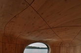 在加拿大安大略省的乔治亚湾地区，这个如同雕塑般的「Grotto」桑拿房栖息在一个私人岛屿的海湾边 ，由当地设计工作室PARTISANS设计和构建。温馨的桑拿浴室内部空间被设想为一个可通风对流的「洞穴」，并以蜿蜒的形式大胆呈现出来，大大的玻璃窗可欣赏到整个海湾的风景，而位于屋顶平面上的天空带来自然采光 。整个建筑大部分皆预制而成，再运输到此安装。（实习编辑：江冬妮）