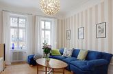 浅色条纹的墙壁让简约的北欧风客厅有了不一样的清新表情，深蓝色的沙发群是客厅最亮丽的主角。（实习编辑：周芝）