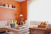 墙面色彩在家居空间中对家居空间的打造往往起着决定性的作用。橙色的墙面，为打造出一个具有鲜活亮色视觉感的空间起着至关重要的铺垫作用。或许是房间的主人为了合理的利用空间因此在墙面上延伸出了一块简易的置物隔板。这块置物板起着简单的收纳作用，可以在置物板上放置一些简易的装饰品或者客厅用具。（实习编辑：周芝）