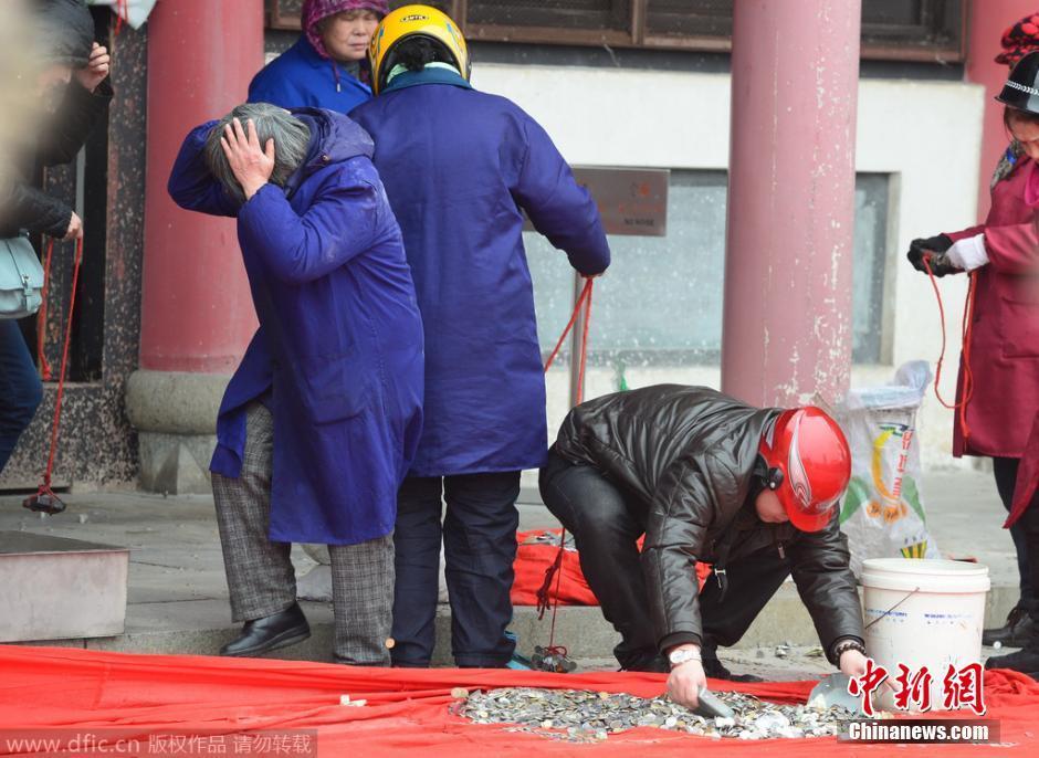 武汉归元寺工作人员戴头盔清理“祈福钱”