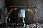 2014年7月23日，广东中山南区一建筑工地。蒋金燕，四川广安人，28岁，在工地做泥水工，包工抹内墙。“泥巴裹满裤腿，汗水湿透衣背”是她每天的工作情景。