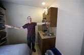 西雅图，克里斯向摄影师介绍他的迷你公寓。在旧金山、纽约和波士顿等大城市，政府正鼓励建造微型公寓，满足年轻上班族、退休人员、单身一族或者学生的需求。2012年秋季，旧金山批准建造最小只有220平方英尺(约合20平方米)的微型公寓。无独有偶，波士顿也批准建造300座新迷你公寓，面积375平方英尺(约合35平方米)。
