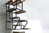 十八、多功能悬浮梯
受设计师Just Haastnoot的委托，Studio Mieke Meijer为他在荷兰瓦圣纳的新家设计了Object  élevé。这一项目由黑钢框架和橡木组成，既作为两个楼层之间的连接、又提供宽阔的工作台、还有收纳存储功能。整个楼梯分左右两边、交替着往上叠加，上半部分可兼为书架之用，下半部分则将搁架、存储柜融入其中，存储日常物品外，还可以在上架摆放植物或其它装饰品，同时还延伸出一张桌子出来。