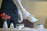一名高级服务员正在为宾客倒茶。
