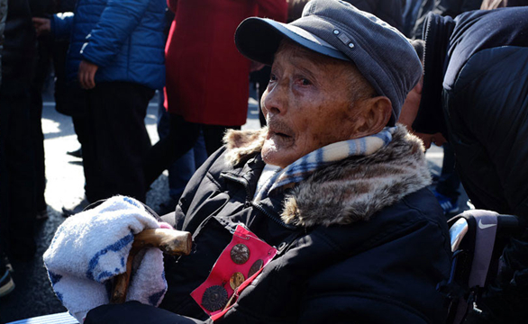 南京大屠杀国家公祭仪式上，一位坐在轮椅上的老兵，不时会拿起毛巾擦拭眼角。