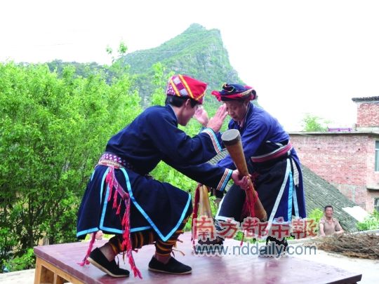 鼓王和儿子在方桌上击鼓起舞，两人身形交错，跳跃旋转，方寸之内别有文章。
