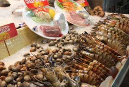 华欣夜市，店家把个头夸张的大头虾、螃蟹摆在门口的冰块上