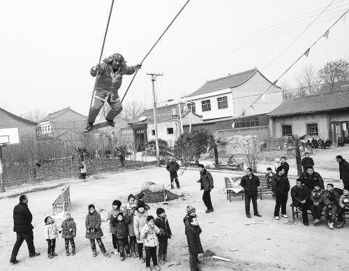 1月31日,在陕西省周至县上阳化村,一名村民身穿古装荡起"独杆秋千".