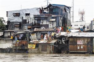 　　在菲律宾奎松城，人们爬上屋顶躲避洪水。 新华社发