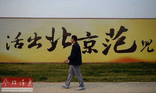 资料图片：2014年4月12日，在河北涿州市，一名市民从一处楼盘广告前走过。新华社记者王晓摄