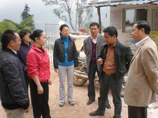 周碧奋（左2）听取屏边县教育局领导汇报工程进展情况