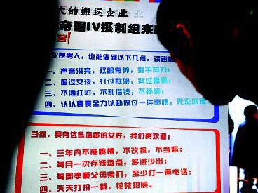 　　大学生小王在仔细观看这则有点雷人的招聘广告，上面写着要求应聘男士“打过群架，背过黑锅”本报记者李晖摄