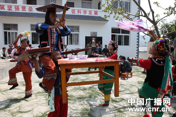 李开富咬着重达40多斤的桌子进行跳菜表演（记者晓兰 摄）