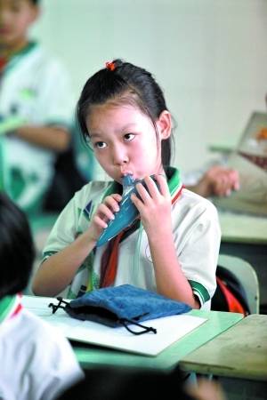 龙涛学校小学生兴致勃勃学吹陶笛.