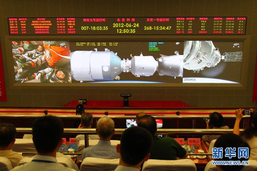 6月24日拍摄的北京航天飞控中心大屏幕显示，神舟九号飞船与天宫一号手控对接成功。