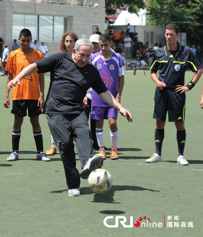当地时间2012年6月11日,以色列耶路撒冷,以色列总理内塔尼亚胡在访问当地一所高中时,展示其踢足球的技术。图片来源:cfp