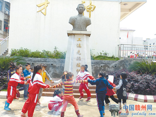 南康市赞贤小学的孩子们在陈赞贤塑像前快乐的游戏