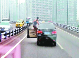 黄泥塝立交，男子打开车门，整个身子悬在车外，看上去十分惊险。（截频图）