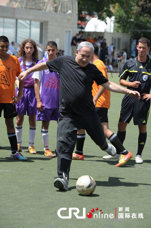 当地时间2012年6月11日,以色列耶路撒冷,以色列总理内塔尼亚胡在访问当地一所高中时,展示其踢足球的技术。图片来源:cfp