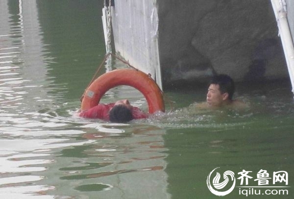 民警刘伟强立即脱下外衣,跳入水中,游到落水男子身边。