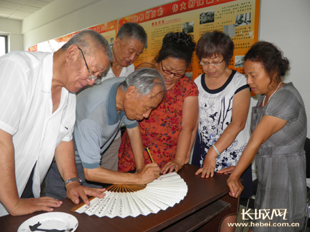 马瑞祥老人在折扇上书写创先争优诗歌 李静宜 摄