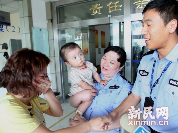 今天中午，失踪男婴在新桥派出所与父母团聚。松江公安分局 供图