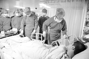 在市第十二人民医院ICU病房内，刘志庚(右二)探望了受伤消防员许育敏，他因吸入大量浓烟和毒气而晕倒，目前已脱离危险。