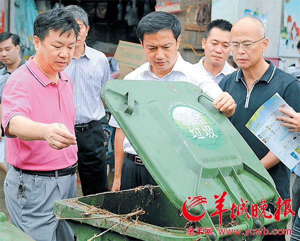 陈小钢(右一,张火青(前右二)在丰乐市场检查厨余垃圾回收处理情况