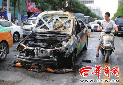出租车内的座椅等被烧光,过往司机向车内探看 本报记者 汤继颖 摄