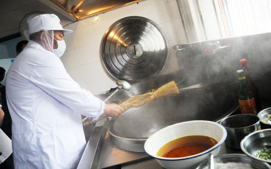 7月3日，黑龙江省绥化市青冈县连丰乡中心小学“希望厨房”的厨师使用新引进的厨房设备做饭。新华社记者 王凯 摄