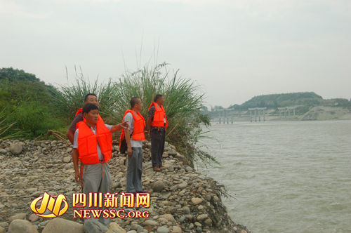 赵舒柳(左一)带领同事在查看金马河险情