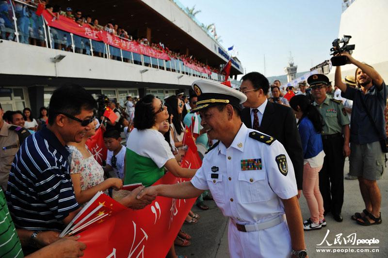 夏克伟少将与前来欢迎华人华侨亲切握手。      摄影：米晋国