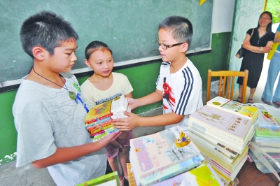 志愿者代表肖国豪给明光金都小学的学生赠送图书.刘浏 摄