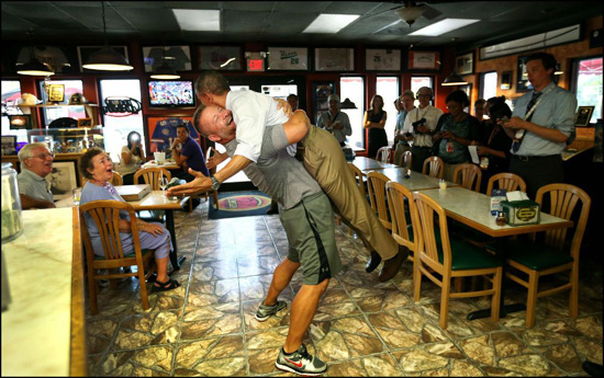 奥巴马遭披萨店东“熊抱”双脚离地（网页截图）
