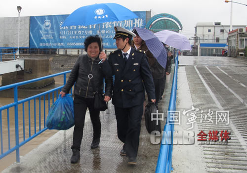 大榭海事处团支部的团员青年为出行的人们送上雨伞。